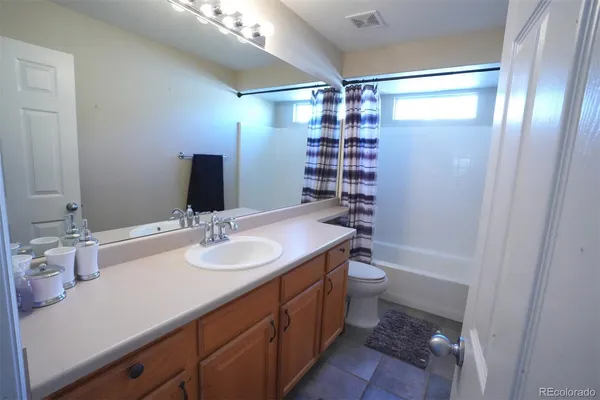a bathroom with a double vanity sink toilet and shower