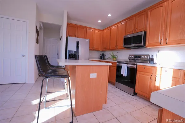 a kitchen with stainless steel appliances granite countertop a stove top oven a sink a dining table and chairs