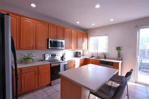 a kitchen with stainless steel appliances granite countertop wooden cabinets a stove top oven a sink and dishwasher