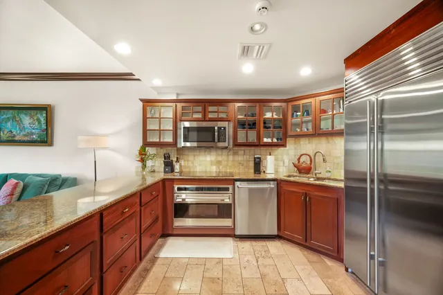 a kitchen with stainless steel appliances granite countertop a refrigerator and a sink