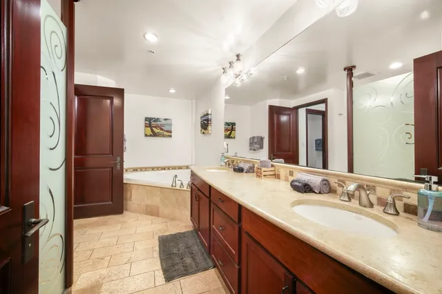 a spacious bathroom with a granite countertop sink a mirror a shower and a bathtub
