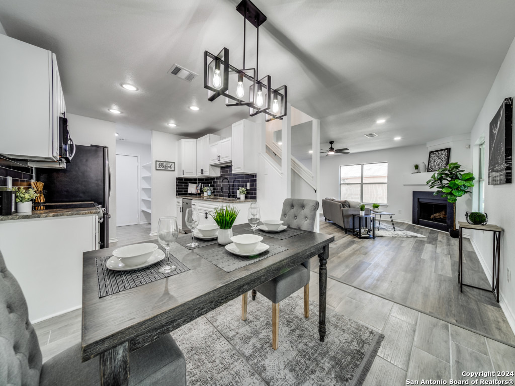 a kitchen with granite countertop kitchen island stainless steel appliances sink cabinets dining table and chair