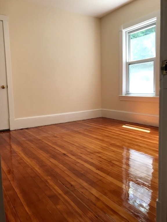 28 Beaconsfield Road, Unit 1 Brookline, MA 02445 - Photo 17 of 21 an empty room with wooden floor and windows
