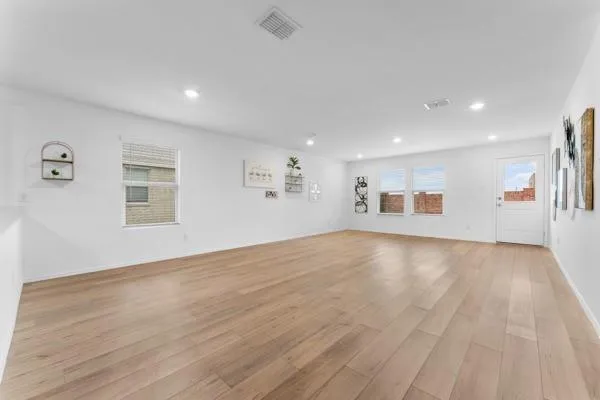 a view of empty room with wooden floor