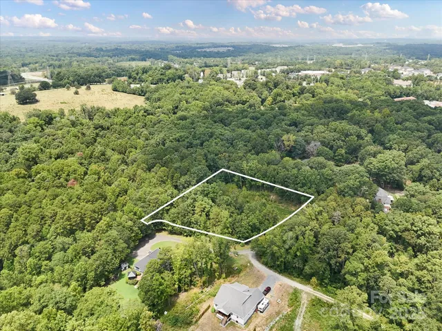 an aerial view of a houses with a yard and mountain