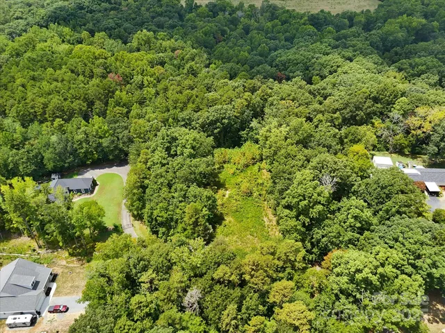 an aerial view of a residential houses with yard