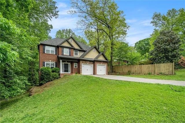 a front view of a house with a yard and trees
