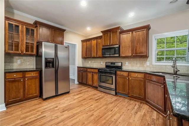 a kitchen with stainless steel appliances granite countertop a refrigerator stove top oven and sink