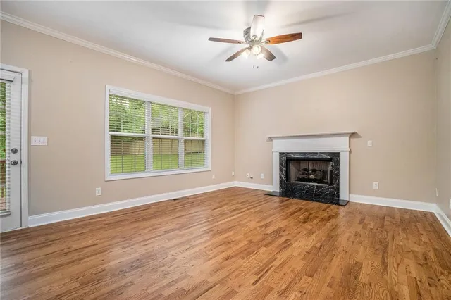 a view of empty room with wooden floor and fireplace