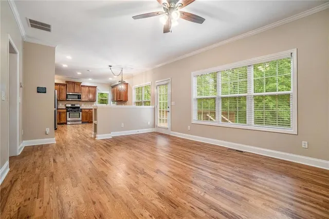 a view of a kitchen with a kitchen island wooden floor and stainless steel appliances