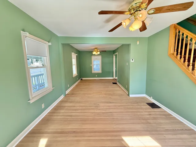 a view of empty room with window and wooden floor