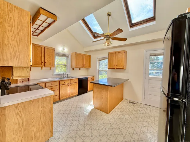 a kitchen with stainless steel appliances granite countertop a refrigerator a stove top oven a sink and dishwasher