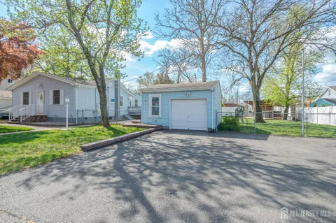 a view of a house with a yard and large tree