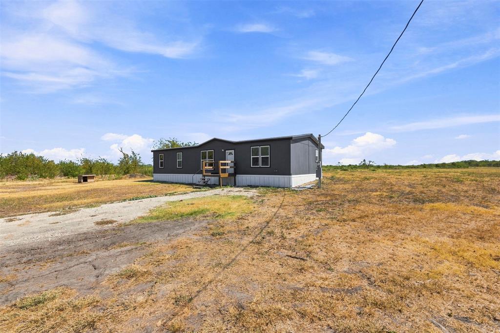 3208 Northeast County Road Powell, TX 75153 - Photo 3 of 29 Manufactured home with dark gray siding, white trim, and multiple windows