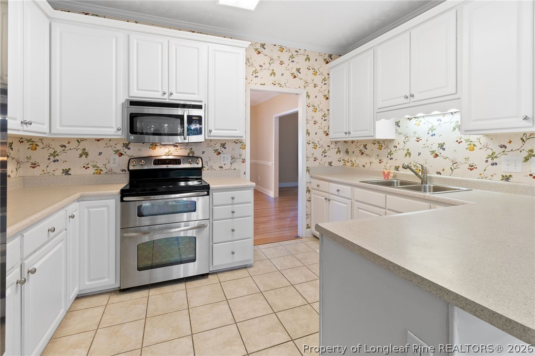 8017 Trout Creek Road Fayetteville, NC 28304 - Photo 12 of 38 a kitchen with white cabinets and appliances