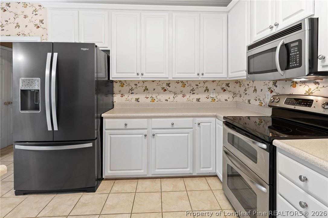 8017 Trout Creek Road Fayetteville, NC 28304 - Photo 14 of 38 a kitchen with stainless steel appliances white cabinets white stove a refrigerator and a microwave