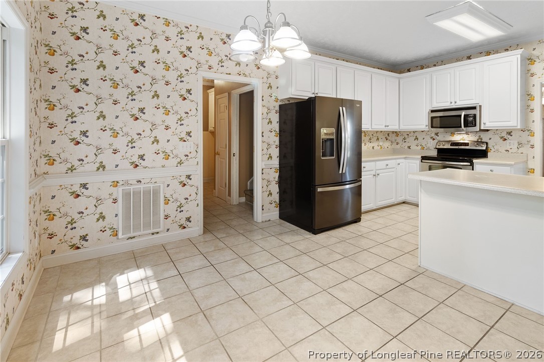8017 Trout Creek Road Fayetteville, NC 28304 - Photo 15 of 38 a kitchen with stainless steel appliances a refrigerator sink and microwave