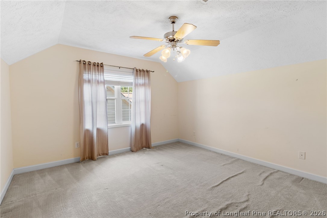8017 Trout Creek Road Fayetteville, NC 28304 - Photo 32 of 38 an empty room with chandelier fan and windows