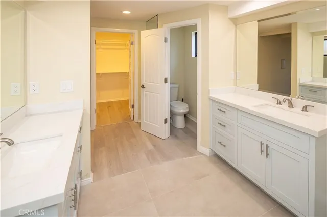 a spacious bathroom with a double vanity sink toilet and shower