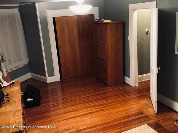 an empty room with wooden floor and closet