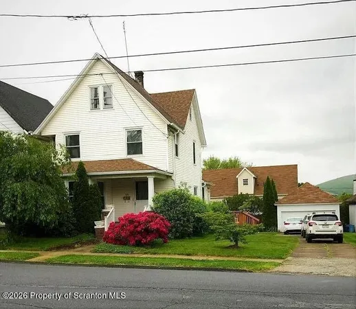 a front view of a house with a garden and garage