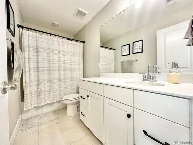 a bathroom with a double vanity sink toilet and shower