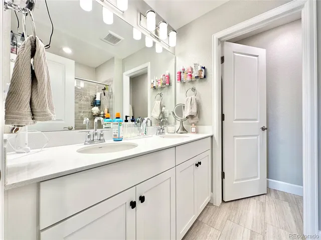 a bathroom with a double vanity sink mirror and