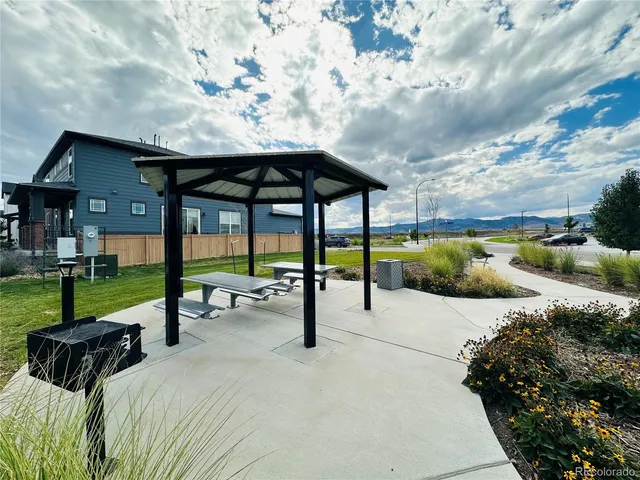 a view of a patio with a table and chairs under an umbrella