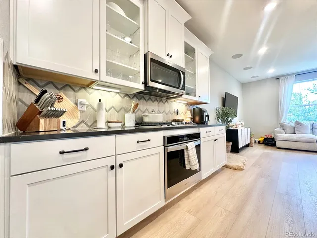 a kitchen with stainless steel appliances granite countertop a stove a sink and a microwave