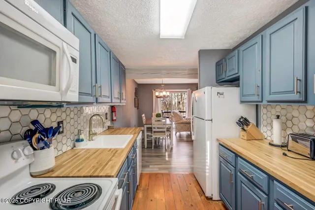 a kitchen with a sink a stove and chairs