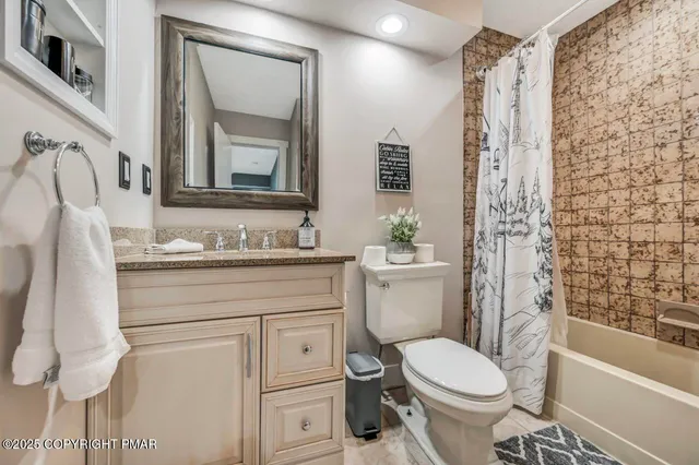a bathroom with a granite countertop sink a toilet and mirror