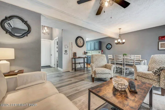 a living room with furniture a clock and a ceiling fan