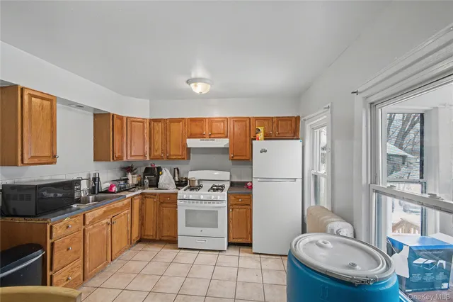 a kitchen with a refrigerator a stove a sink dishwasher and white cabinets with wooden floor