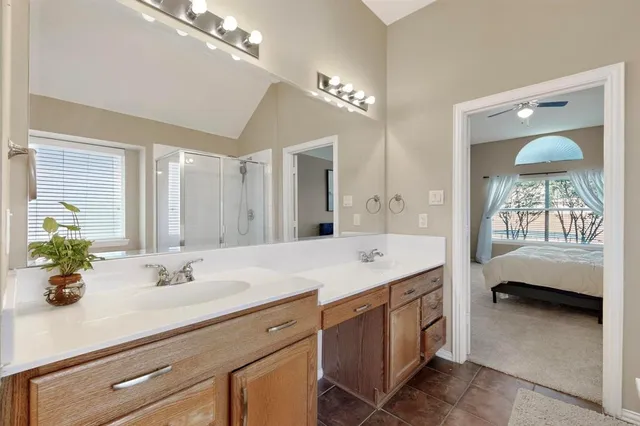 a en suite bathroom with a double vanity sink and a mirror