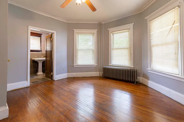 an empty room with wooden floor and windows