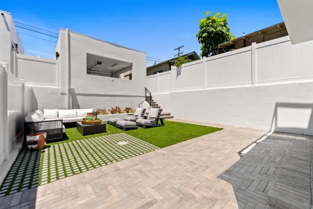 a view of a patio with couches table and chairs with wooden floor and fence