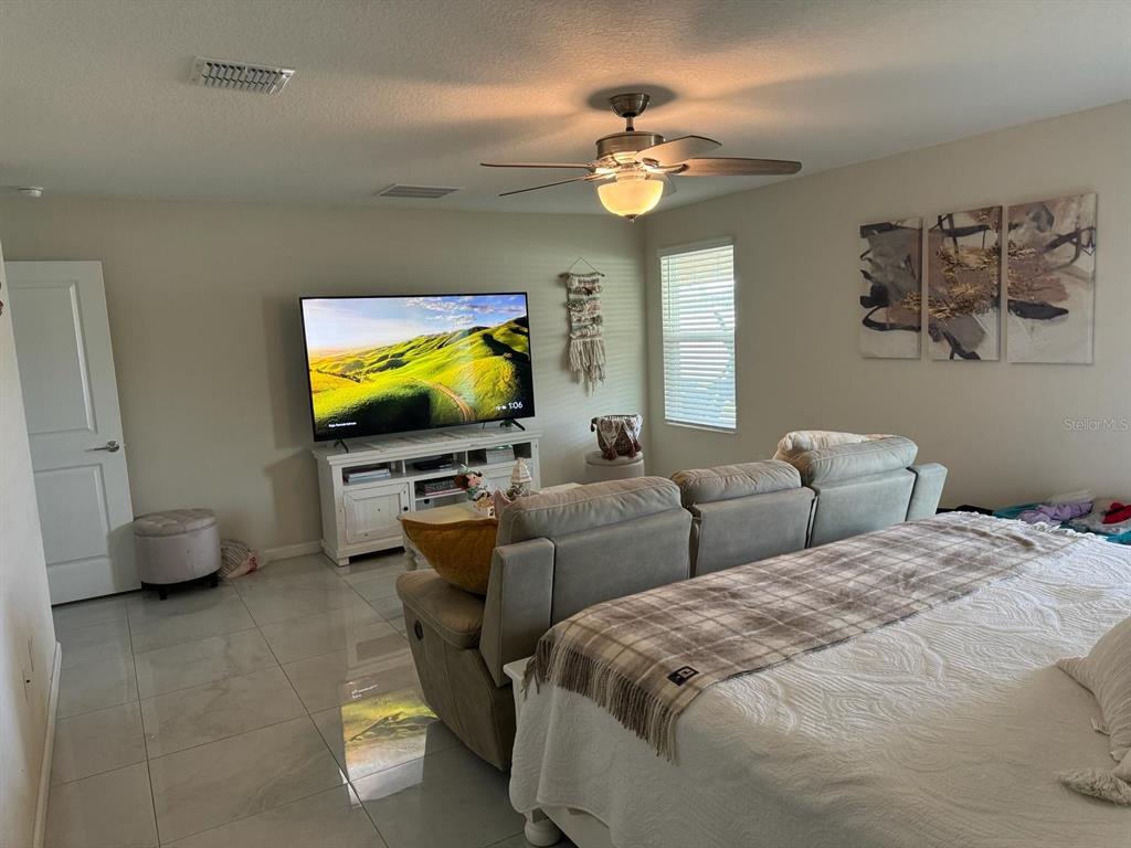 4499 Magnolia Ridge Court Kissimmee, FL 34746 - Photo 20 of 43 a bedroom with a bed and a flat screen tv