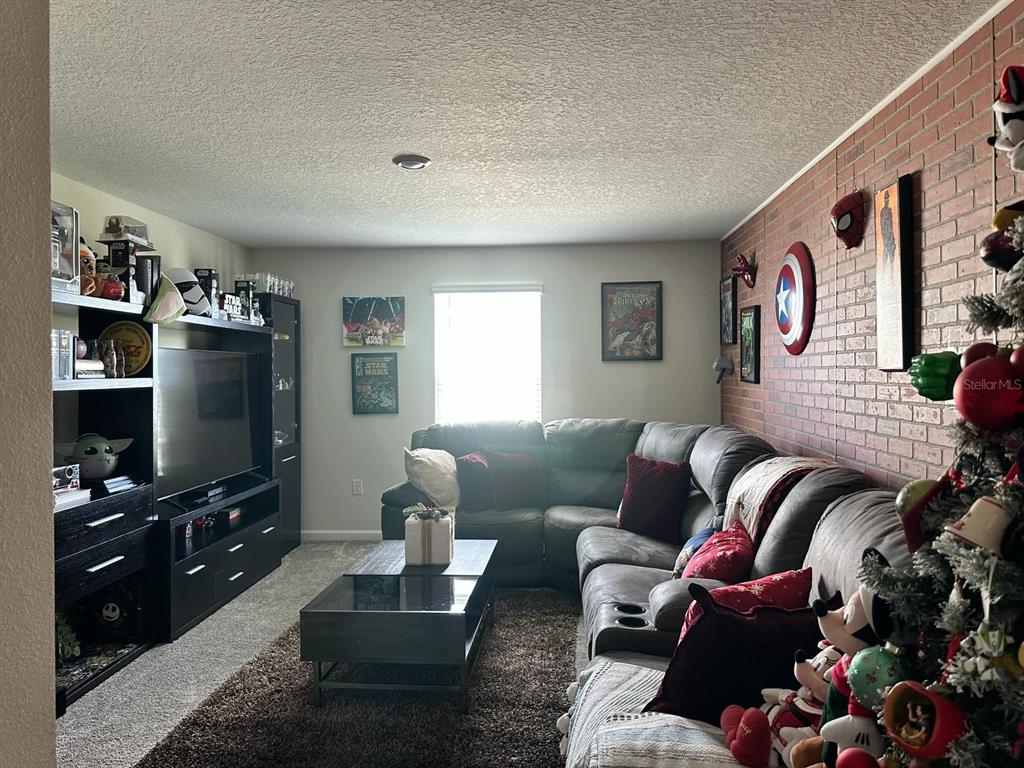 4499 Magnolia Ridge Court Kissimmee, FL 34746 - Photo 10 of 43 a living room with furniture and a flat screen tv