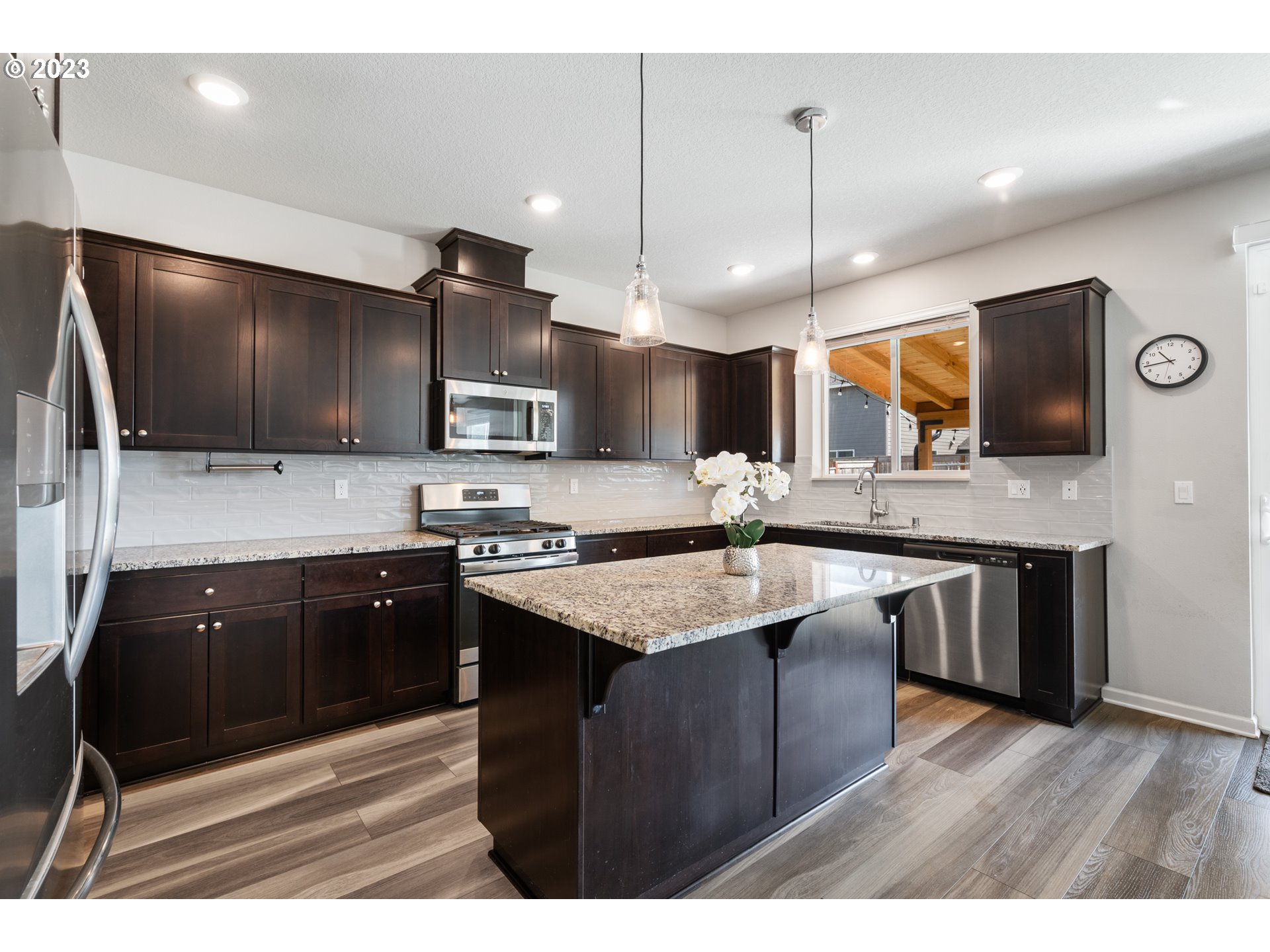 3912 South 41st Place Ridgefield, WA 98642 - Photo 5 of 20 a kitchen with stainless steel appliances kitchen island granite countertop a sink stove and microwave