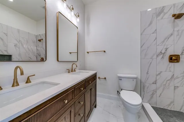 a bathroom with a granite countertop toilet sink and mirror