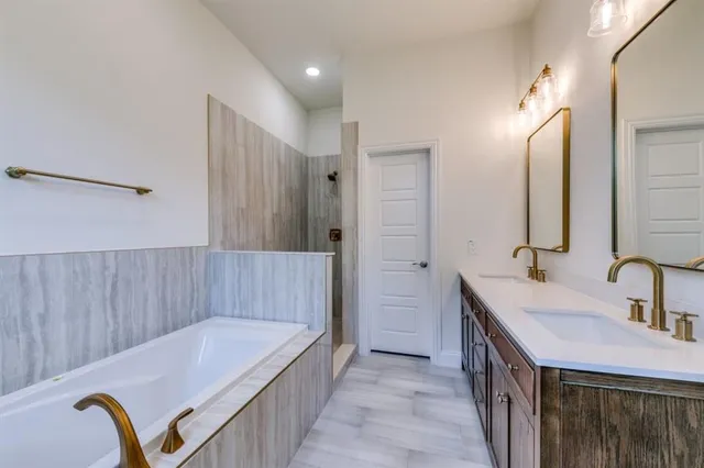 a bathroom with a tub sink and mirror