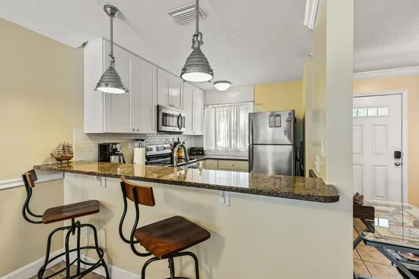 a kitchen with stainless steel appliances granite countertop a refrigerator a stove a sink and a granite counter tops