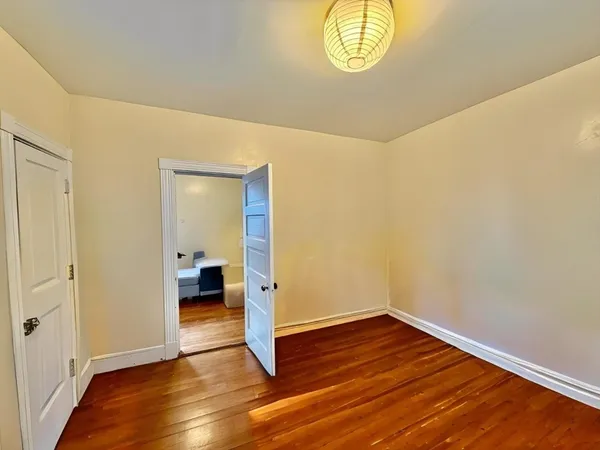 a view of empty room with wooden floor