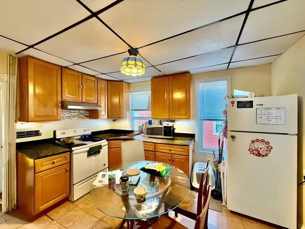 a kitchen with stainless steel appliances granite countertop a stove a sink dishwasher and white cabinets with wooden floor