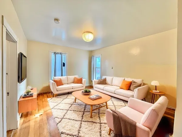 a living room with furniture a flat screen tv and a table