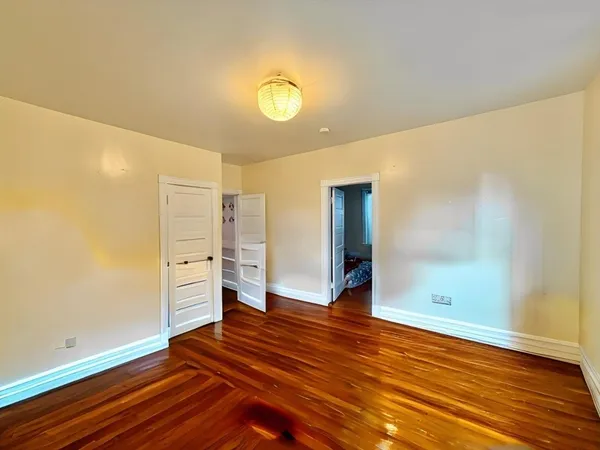 a view of an empty room with wooden floor