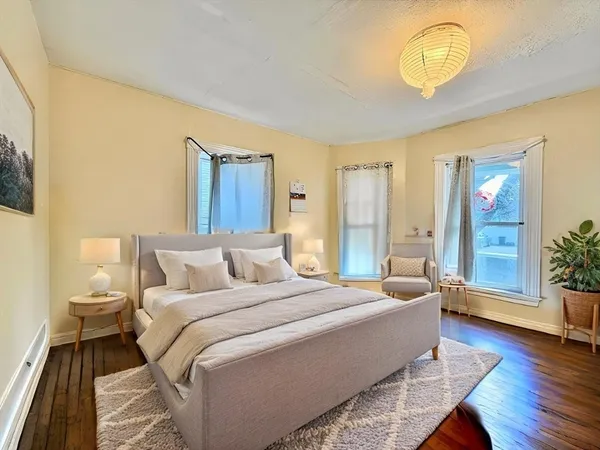 a bedroom with a bed and wooden floor