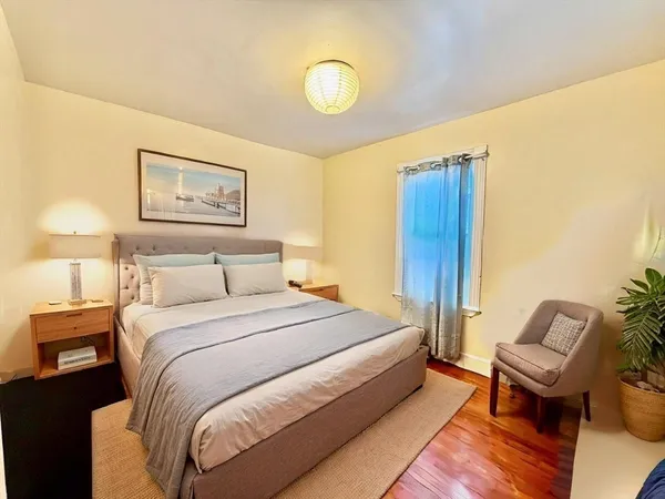 a spacious bedroom with a bed and chair