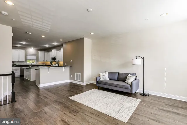 a living room with furniture and kitchen view