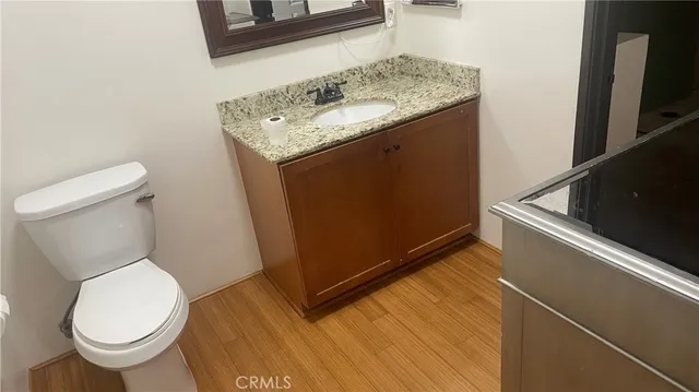 a bathroom with a granite countertop toilet and a sink